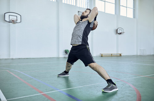 Mann mit Basketball, Stretching, Indoor - ZEDF01380