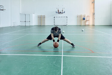 Mann mit Basketball, Beine ausstrecken, indoor - ZEDF01381