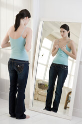 Frau betrachtet ihre Brust im Spiegel - ISF00073