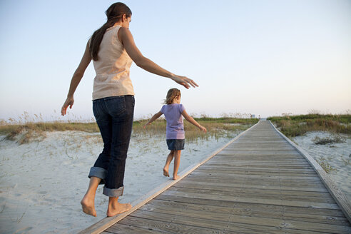 Mutter und Tochter gehen auf dem Strandweg spazieren - ISF00116