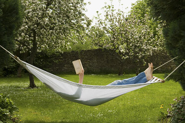 Woman in hammock reading book - ISF00141