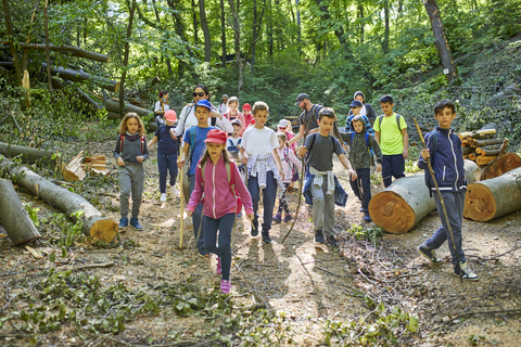 Adults and kids on a field trip in forest stock photo