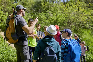 Mann spricht mit Kindern bei einem Ausflug auf einem Wanderweg - ZEDF01399