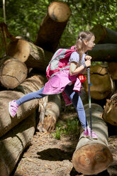 Girl balancing on logs in forest - ZEDF01405