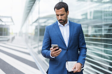 Portrait of businessman using smartphone - DIGF04182