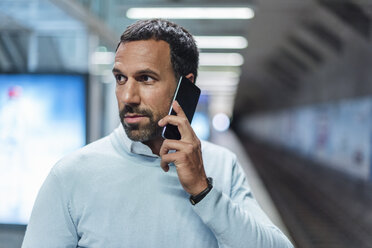 Businessman using smartphone at metro station - DIGF04236