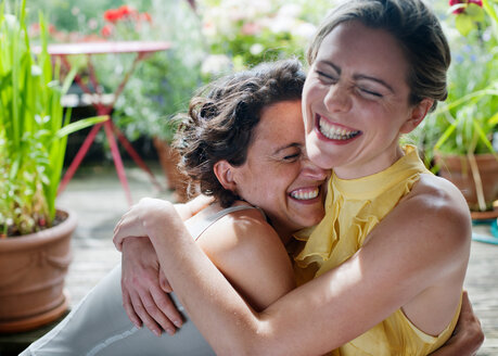 Two women hugging on balcony - CUF01131