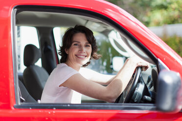 Frau lächelnd auf dem Fahrersitz eines Autos - CUF01177