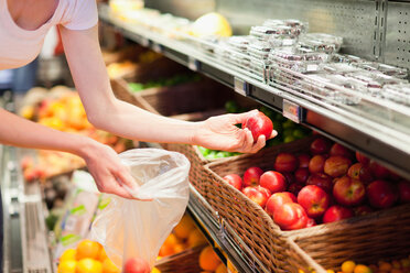 Woman selecting fruit at grocery store - CUF01178