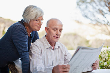 Older couple reading newspaper outdoors - CUF01181