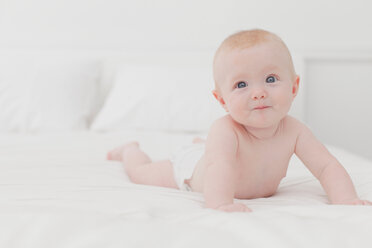 Lächelndes Baby auf dem Bett liegend - CUF01205