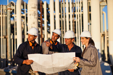 Workers with blueprints at oil refinery - CUF01217