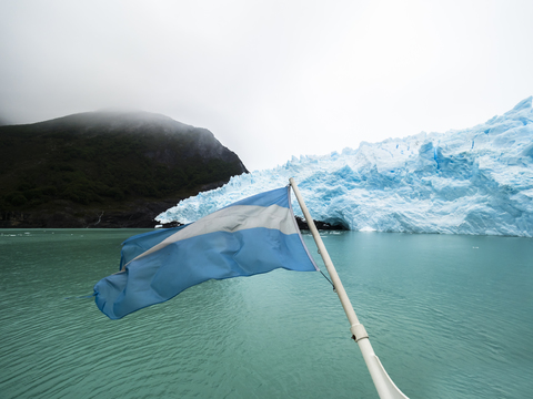 Argentinien, Patagonien, El Calafate, Puerto Bandera, Lago Argentino, Parque Nacional Los Glaciares, Estancia Cristina, Spegazzini-Gletscher, argentinische Flagge und Eisberg, lizenzfreies Stockfoto