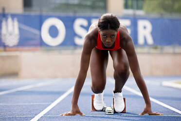 Foto de Full length of African American female athlete at starting block on  race track do Stock