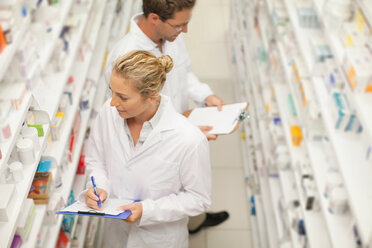 Pharmacists browsing medicines on shelf - CUF01283