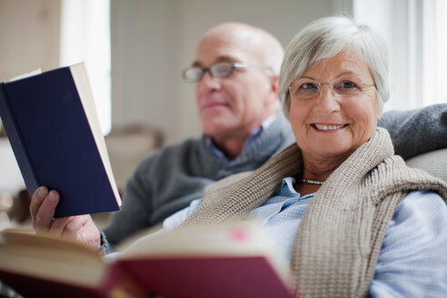 Lächelndes älteres Paar beim Lesen von Büchern - CUF01364