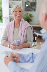 Lächelndes älteres Paar spielt Karten - CUF01365