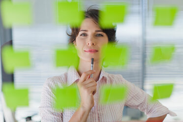 Businesswoman reading sticky notes - CUF01373