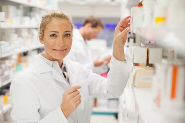 Pharmacists browsing medicines on shelf - CUF01374