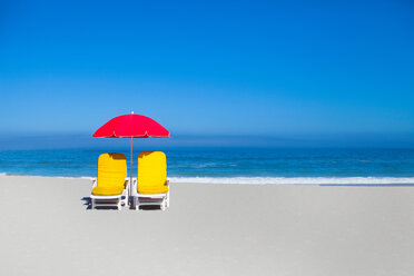 Empty lawn chairs and umbrella on beach - CUF01428