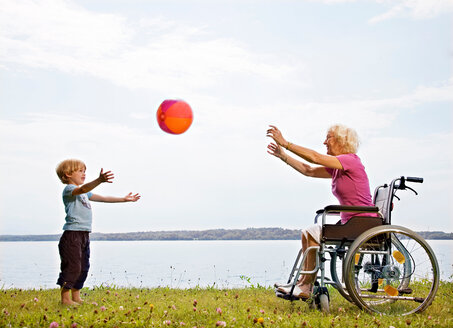 Junge spielt Ball mit älterer Frau - CUF01561