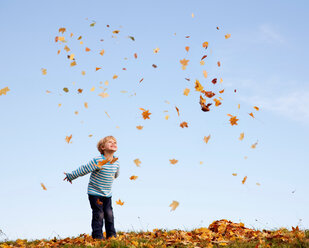 Boy throwing autumn leaves into the air - CUF01567