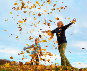 Vater und Sohn spielen im Herbstlaub - CUF01597