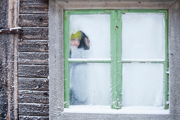 Frau blickt aus frostigem Fenster - CUF01611