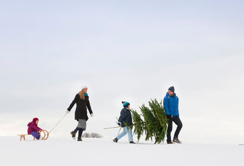 Familie beim gemeinsamen Spaziergang im Schnee - CUF01612