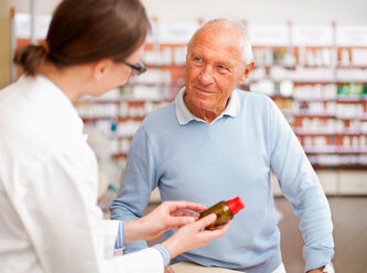 Pharmacist talking to patient in store - CUF01613