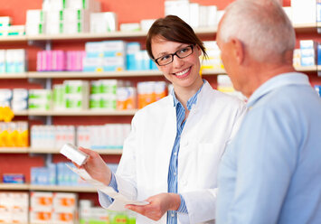 Pharmacist talking to patient in store - CUF01614