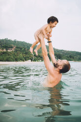 Thailand, Koh Lanta, Vater spielt mit seiner kleinen Tochter im Meer - GEMF01928