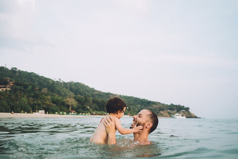 Thailand, Koh Lanta, Vater spielt mit seiner kleinen Tochter im Meer, lizenzfreies Stockfoto
