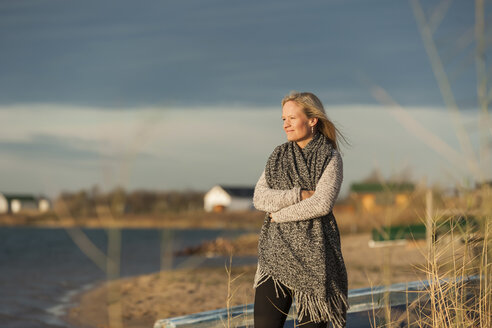 Woman standing at lake shore, enjoying the sun - PAF01835