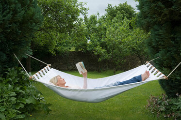 Woman relaxing in hammock in garden - CUF01826