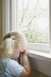 Sad little girl by window - ISF00262