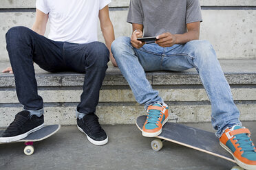 Teenager mit Skateboard und Mobiltelefon - ISF00331