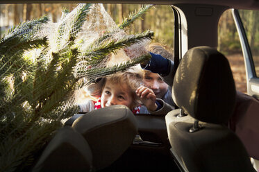 Zwei Jungen betrachten einen Weihnachtsbaum im Auto - ISF00357