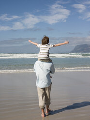 Mann trägt seinen Sohn über das Meer - ISF00410