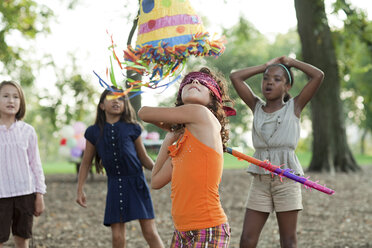 Girl at birthday party hitting pinata - ISF00425