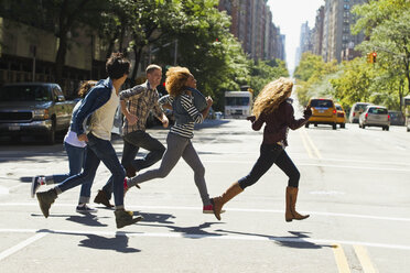 Five friends running through city street - ISF00430