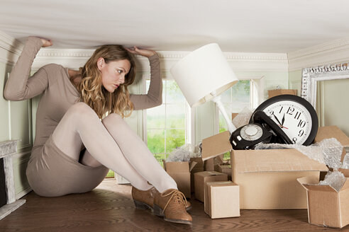 Young woman with box of objects in small room - ISF00496