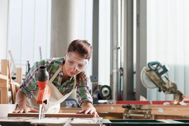 Schreiner bei der Arbeit mit der Säge in der Werkstatt - ISF00580