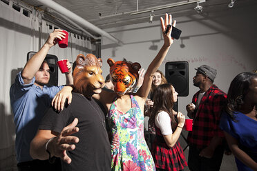 Menschen mit Löwen- und Tigermasken tanzen auf einer Party - ISF00620