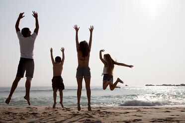 Familie, die am Strand in die Luft springt - ISF00631