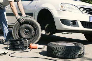 Man changing car tires, partial view - MAEF12572