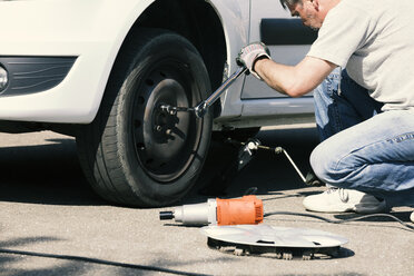 Man changing car tire - MAEF12574