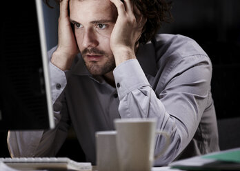 Stressed young man, working late - ISF00640