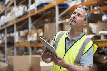 Man in warehouse using digital tablet - ISF00648