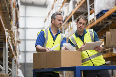 Two men checking stock in warehouse - ISF00649